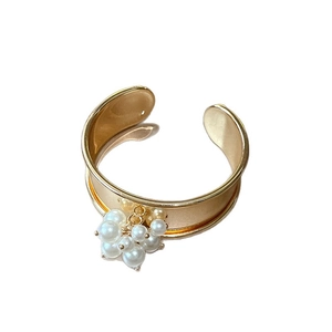 Golden wide open ring with clustered pearls featuring a retro and minimalist metallic design