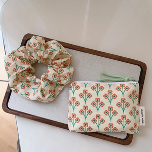 Detail of floral scrunchie and matching pouch with orange flowers and simple wish label