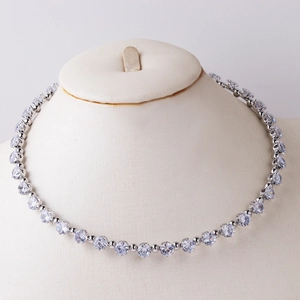 Elegant silver tennis necklace with heart and drop zircons on a mannequin model