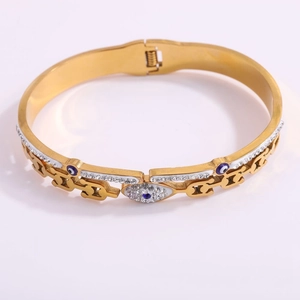 Detailed shot of gold plated evil eye bangle with blue rhinestones and cutout design