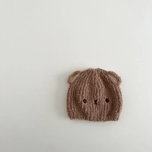 Detailansicht einer braunen Baby-Plüschmütze mit Tierohren und weicher Textur