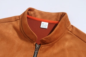 Detail of brown suede jacket showing stand collar, silver zipper, and soft fabric texture