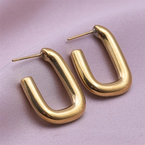 Close-up of gold U-shaped 304 stainless steel earrings on soft purple fabric