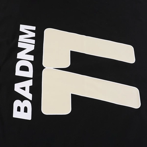 Macro shot of high-quality screen printed BADNM 11 lettering on black knit sweatshirt fabric