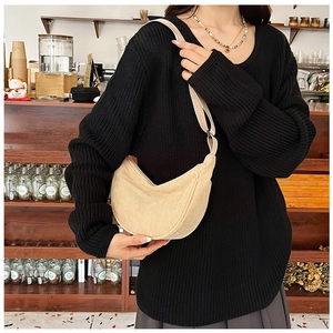 Beige corduroy crescent bag shown on model in a cozy vintage cafe setting