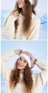 Detail of cable knit texture and faux fur trim on a pink and white winter beanie