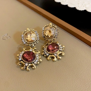 Close-up of vintage gold earrings with champagne and burgundy crystals and rhinestones