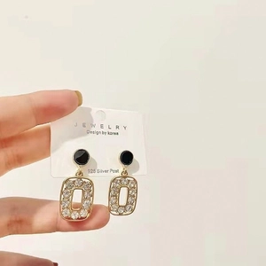 Macro shot of 925 silver post geometric earrings with rhinestones on a card