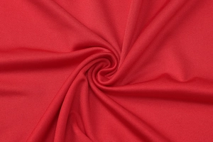 Macro detail of the premium red knitted elastic fabric with soft texture and refined sheen