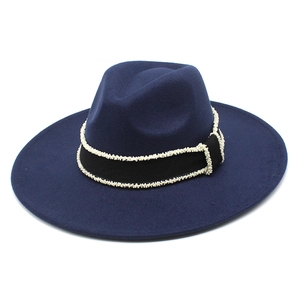 Close-up of navy wool fedora hat featuring black ribbon and delicate white bead trim