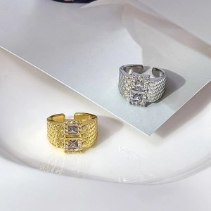 Detail view of gold and silver castle wall rings with dual square zircon stones