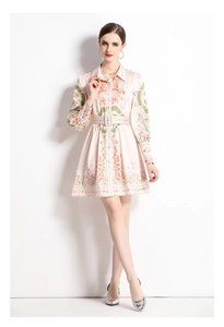 Detail of light pink floral shirt dress featuring tropical print and matching waist belt