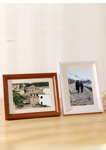Detail view of dark wood and white minimalist picture frames on a wooden table