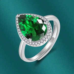 Detail of pear-cut green gemstone ring with cubic zirconia accents on silver band