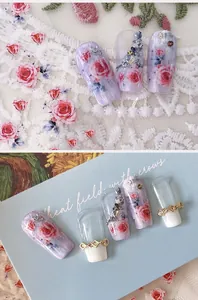 Close-up of red rose nail art stickers with 3D rhinestones and gold accents