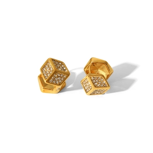 Gros plan de boucles d'oreilles cubes dorées serties de zircons cubiques brillants