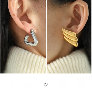 Macro shot of silver geometric triangle hoop and gold textured ear studs for women