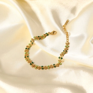 Detail view of olive leaf bracelet with green enamel on champagne silk background