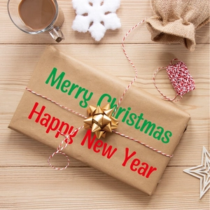 Festive gift box with golden bow on wood background with Christmas decorations