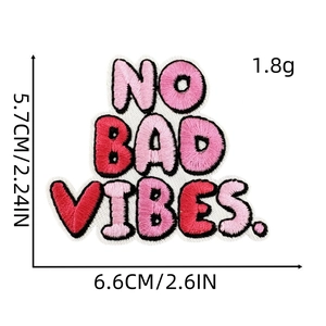 Macro view of NO BAD VIBES embroidered iron-on patch with pink and red stitch details
