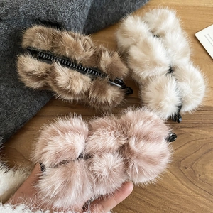Détail de pinces à cheveux en fausse fourrure marron, beige et rose pour l'hiver