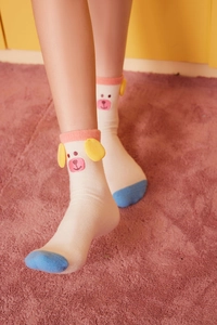 Detail of soft coral fleece socks with cute cartoon bear ears and pink ribbed cuffs