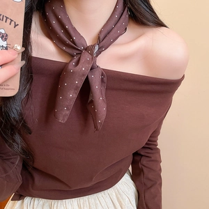 Detail view of coffee-colored knit top with brown polka dot silk scarf necklace