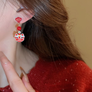 Detailed close-up of a red Chinese lion dance earring on model for New Year