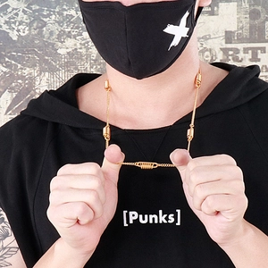 Close-up of golden spring charm necklace worn by model against a street style wall