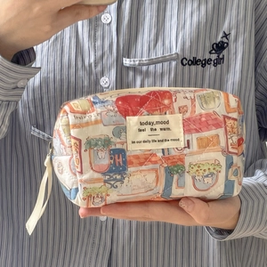 Detail of hand-drawn quilted animal kingdom makeup bag with portable handle and zipper