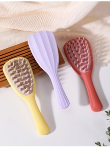 Three colorful gingko leaf silicone hair scalp massagers on a decorative tray