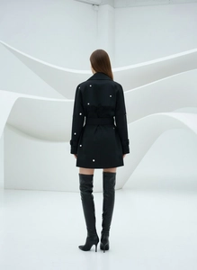 Détail de la robe noire cintrée avec œillets métalliques et tissu de haute qualité