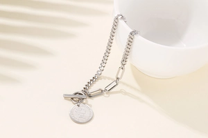 Detailed shot of silver coin bracelet with link chain design and toggle clasp closure