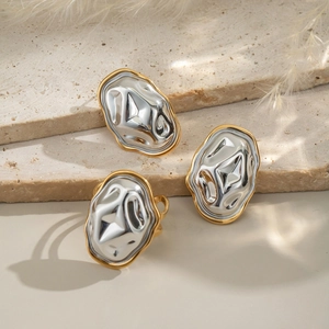 Détail de bijoux géométriques argentés à bords dorés avec texture martelée sur pierre
