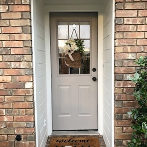 Close-up of spring hydrangea door basket with white flowers, green leaves and a ribbon bow