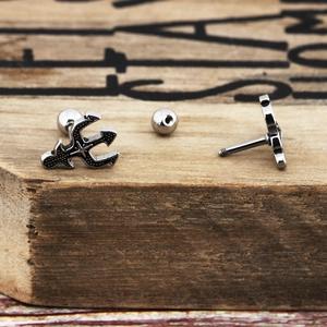 Macro view of vintage silver cross earring with detailed gothic texture and screw back