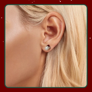 Close-up of a model wearing the red Santa hat pearl stud earrings in S925 silver