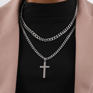 Close-up of double-layered silver stainless steel chain with cross pendant on male model