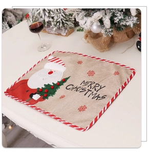 Close-up of linen Christmas placemat with Santa embroidery and red striped edging