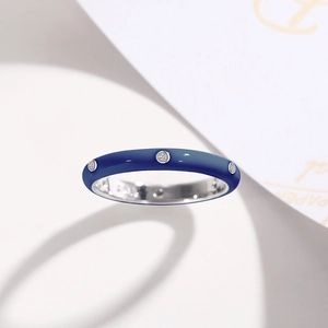 Close-up of deep blue enamel ring with sparkling zircons on a minimal white background