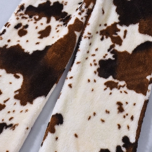 Gros plan sur le tissu en polaire imprimé vache marron et blanc pour pantalon d'hiver