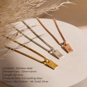 Three minimalist stainless steel square initial necklaces in gold, silver, and rose gold