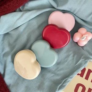 Macro view of heart-shaped contact lens cases in four pastel glossy colors
