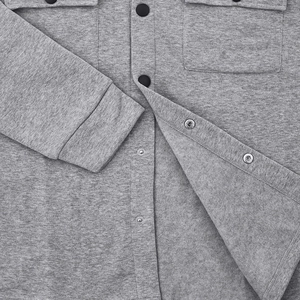 Detail of gray fleece jacket texture with metallic snap buttons and premium knit fabric