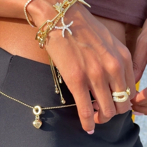 Détail du bracelet étoile de mer doré et de la bague trombone sertie sur mannequin
