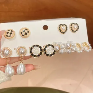 Dettaglio di un set da 6 paia di orecchini vintage con perle e fiori di camelia