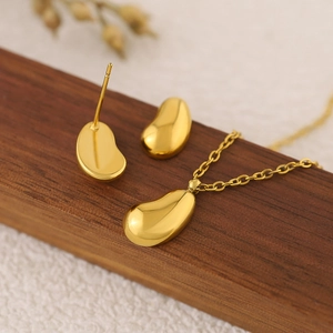 Minimalist gold bean jewelry set featuring polished water drop earrings and necklace