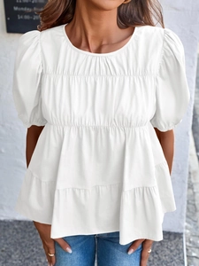 Detail of white puff sleeve blouse with pleated tiered design and relaxed doll-style fit