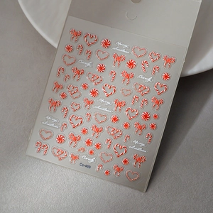 Macro view of Christmas candy nail stickers featuring embossed candy canes and bows