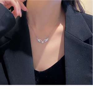 Detail of angel wing heart pendant with sparkling cubic zirconia on a model